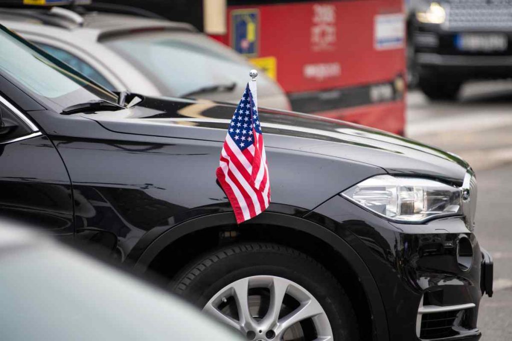 A brand new black SUV with a small American flag for decoration