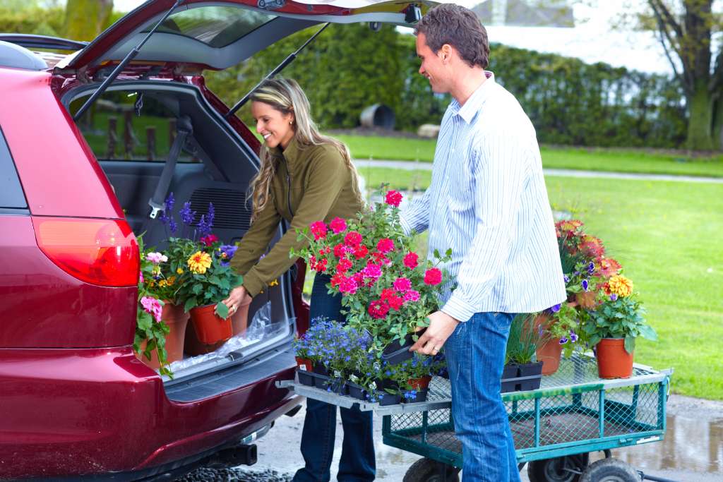 A young couple loads up their new car with beautiful spring flowers